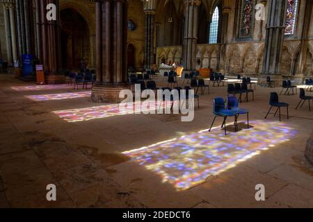 Le motif de vitraux s'illumine sur le sol en pierre à l'intérieur de la cathédrale de Lincoln, Lincoln, Lincolnshire, Royaume-Uni. Banque D'Images