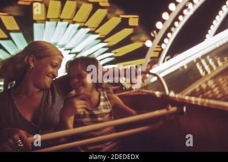 'Photos des années 1970 (1973) - Wanda Shemwell et sa fille susan (9) font un tour sur le Trabant ; un tour d'amusement allemand à ''Fun City' sur ''The Strip.' mme Shemwell et susan sont des visiteurs fréquents de ''Fun City''. Les puits ont leur propre maison sur le lac (lac de la région Ozarks Missouri) ' Banque D'Images