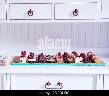 Sélection de desserts à gâteau colorés et délicieux sur plateau sur le plan de travail de la cuisine. Banque D'Images