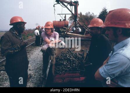 L'équipe de réparation de voie du Southern Railway travaille autour de l'équipement utilisé pour retirer les anciennes voies et les remplacer par des voies ferrées d'un quart de mille de long ca. 1974 Banque D'Images