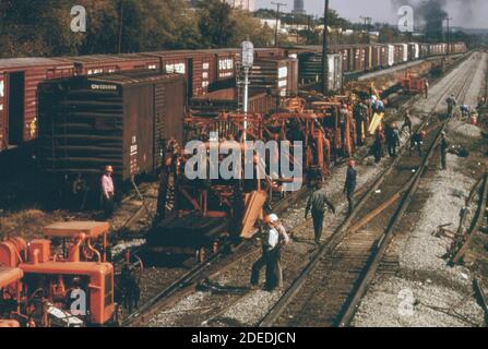 L'équipe de travail de l'emprise du Southern Railway et les travailleurs de la machinerie remplacent les anciennes traverses de chemin de fer par de nouvelles pour améliorer la plate-forme. CA. 1974 Banque D'Images