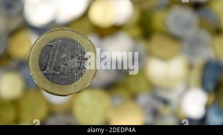 Un gros plan montre une pièce de 1 euro. C'est de l'argent. Fond d'argent flou. Au verso, il y a une carte élargie des pays de l'UE. Matériau Banque D'Images