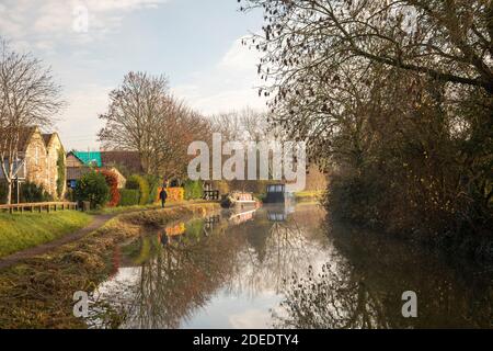 Bateau-canal amarré à côté du chemin de halage à la fin de l'automne sur le canal Kennet et Avon lors d'un matin d'hiver ensoleillé et brumeux, Bradford on Avon, Wiltshire, Royaume-Uni Banque D'Images