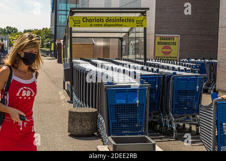 Chariots à provisions désinfectés devant un supermarché français à Mulhouse, France Banque D'Images