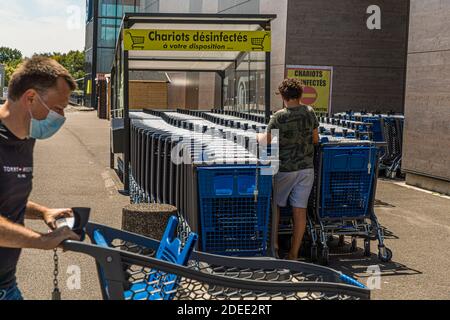 Chariots à provisions désinfectés devant un supermarché français à Mulhouse, France Banque D'Images