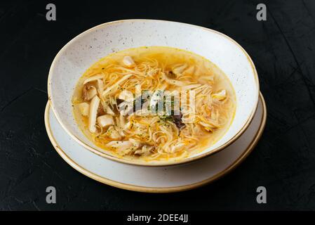 bouillon de poulet avec nouilles sur fond noir texturé Banque D'Images