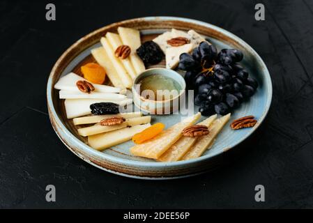 assiette de fromages avec une variété de fromages sur un noir arrière-plan Banque D'Images