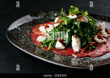 carpaccio de bœuf en marbre sur fond noir Banque D'Images