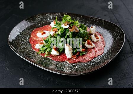 carpaccio de bœuf en marbre sur fond noir Banque D'Images