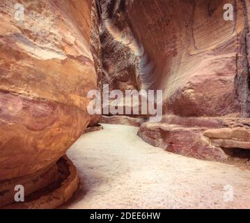 Le Siq, l'encoche étroite-canyon qui sert de couloir d'entrée à la ville cachée de Petra, Jordanie Banque D'Images