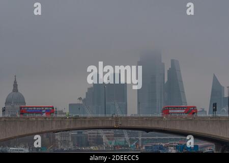Londres, Royaume-Uni. 30 novembre 2020. La ville de Londres, partiellement cachée, offre une toile de fond grise aux autobus qui passent au-dessus du pont de Waterloo, dont beaucoup ont des messages qui s'affichent à Covid 19. Un matin brumeux, une certaine vie se poursuit à Londres alors que le second coronavirus Lockdown approche de sa fin crédit: Guy Bell/Alamy Live News Banque D'Images