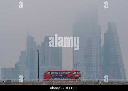 Londres, Royaume-Uni. 30 novembre 2020. La ville de Londres, partiellement cachée, offre une toile de fond grise aux autobus qui passent au-dessus du pont de Waterloo, dont beaucoup ont des messages qui s'affichent à Covid 19. Un matin brumeux, une certaine vie se poursuit à Londres alors que le second coronavirus Lockdown approche de sa fin crédit: Guy Bell/Alamy Live News Banque D'Images