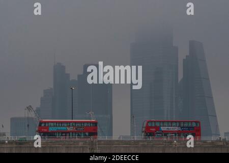 Londres, Royaume-Uni. 30 novembre 2020. La ville de Londres, partiellement cachée, offre une toile de fond grise aux autobus qui passent au-dessus du pont de Waterloo, dont beaucoup ont des messages qui s'affichent à Covid 19. Un matin brumeux, une certaine vie se poursuit à Londres alors que le second coronavirus Lockdown approche de sa fin crédit: Guy Bell/Alamy Live News Banque D'Images