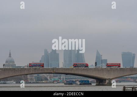 Londres, Royaume-Uni. 30 novembre 2020. La ville de Londres, partiellement cachée, offre une toile de fond grise aux autobus qui passent au-dessus du pont de Waterloo, dont beaucoup ont des messages qui s'affichent à Covid 19. Un matin brumeux, une certaine vie se poursuit à Londres alors que le second coronavirus Lockdown approche de sa fin crédit: Guy Bell/Alamy Live News Banque D'Images
