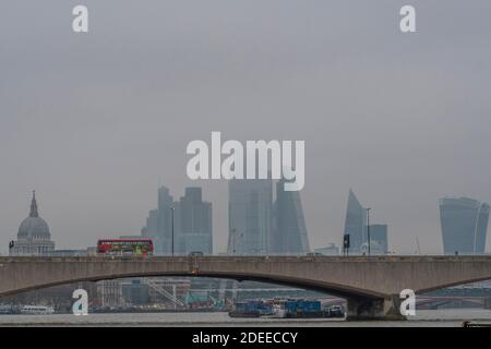 Londres, Royaume-Uni. 30 novembre 2020. La ville de Londres, partiellement cachée, offre une toile de fond grise aux autobus qui passent au-dessus du pont de Waterloo, dont beaucoup ont des messages qui s'affichent à Covid 19. Un matin brumeux, une certaine vie se poursuit à Londres alors que le second coronavirus Lockdown approche de sa fin crédit: Guy Bell/Alamy Live News Banque D'Images
