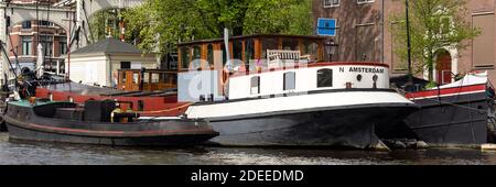 AMSTERDAM, PAYS-BAS - 01 MAI 2018 : vue panoramique sur les bateaux amarrés sur un canal Banque D'Images