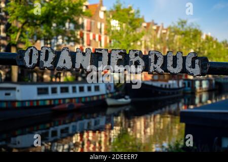 AMSTERDAM, PAYS-BAS - 01 MAI 2018 : panneau en métal sur le pont Oranjebrug en traversant le canal Brouwersgracht avec une vue défoculisée sur les bateaux Banque D'Images