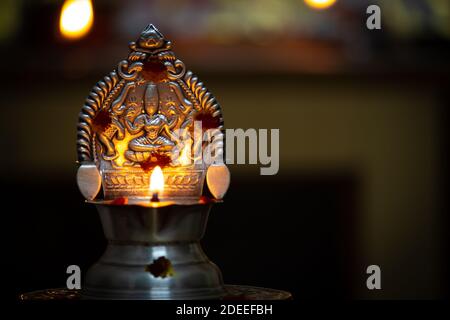 Vue rapprochée de la lampe diya allumée. Lampe en métal argenté allumée pendant le festival. Banque D'Images