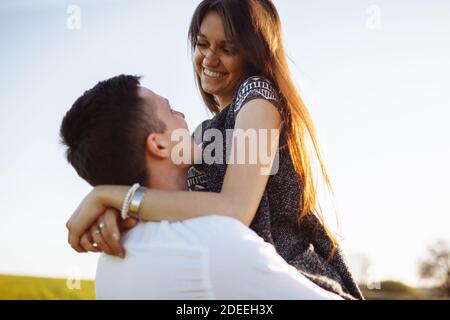 jeune, heureux, couple aimant, à l'extérieur, homme tenant une fille dans ses bras , et en appréciant les uns les autres, la publicité, Banque D'Images