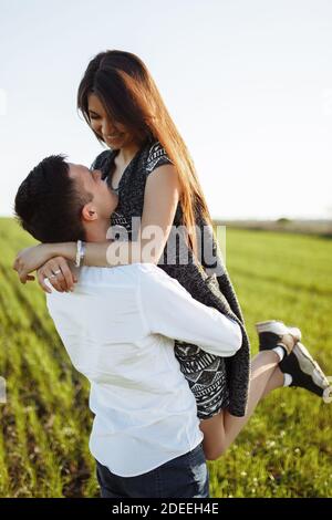 jeune, heureux, couple aimant, à l'extérieur, homme tenant une fille dans ses bras , et en appréciant les uns les autres, la publicité, Banque D'Images