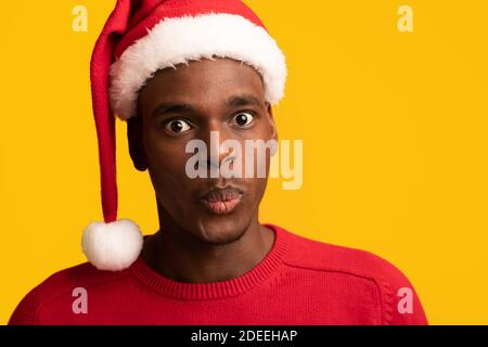 Stupéfait Black Guy de Santa Hat réagissant émotionnellement à choquant Offre de Noël Banque D'Images