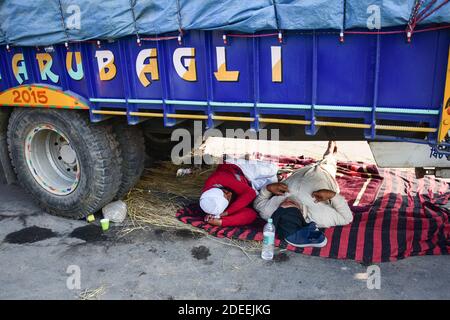 Alipur, Inde. 30 novembre 2020. Les agriculteurs sont vus reposer sous le tracteur pendant la démonstration. Selon le syndicat des agriculteurs, des milliers d'agriculteurs de différents États se sont déplacés vers la capitale de l'Inde pour protester contre les nouvelles lois agricoles qui, selon eux, nuirait gravement à leurs revenus. Crédit : SOPA Images Limited/Alamy Live News Banque D'Images