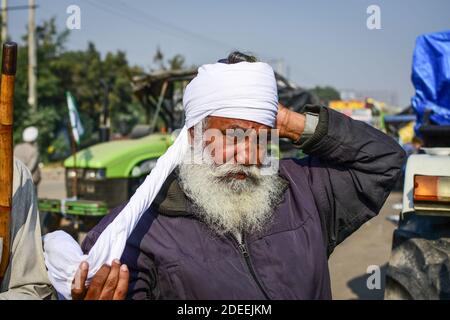 Alipur, Inde. 30 novembre 2020. Un fermier a vu lier son turban alors qu'il se prépare à prendre part à la manifestation. Selon le syndicat des agriculteurs, des milliers d'agriculteurs de différents États se sont déplacés vers la capitale de l'Inde pour protester contre les nouvelles lois agricoles qui, selon eux, nuirait gravement à leurs revenus. Crédit : SOPA Images Limited/Alamy Live News Banque D'Images