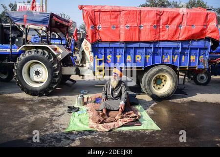 Alipur, Inde. 30 novembre 2020. Un agriculteur s'assoit près de son tracteur a pendant qu'il participe à la démonstration. Selon le syndicat des agriculteurs, des milliers d'agriculteurs de différents États se sont déplacés vers la capitale de l'Inde pour protester contre les nouvelles lois agricoles qui, selon eux, nuirait gravement à leurs revenus. Crédit : SOPA Images Limited/Alamy Live News Banque D'Images