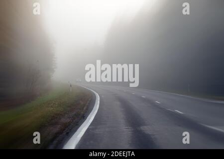 La conduite sur route de campagne dans le brouillard. Illustration des dangers de la conduite dans de mauvaises conditions météorologiques : brumeux, difficile de voir de l'avant Banque D'Images