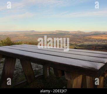 Une photographie d'un banc de pique-nique en bois givré au sommet d'un Point de vue sur la montagne dans le sud du pays de Galles surplombant le Brecons Beacons National stationnement Banque D'Images