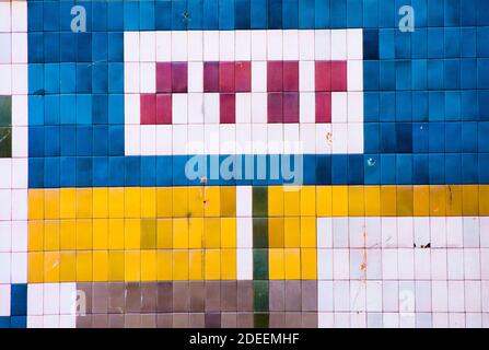 Mot d'arrêt en carreaux rouges. Mur recouvert de carreaux de couleur bleu, jaune et rouge. Design géométrique des années 70. Banque D'Images