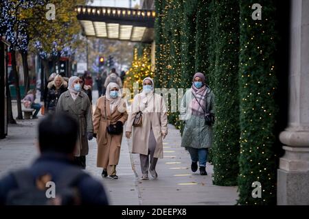 Avant la réouverture des entreprises et avant le passage à un niveau 2 pour Londres lors de la deuxième vague de la pandémie du coronavirus, les acheteurs passent devant les vitrines de Noël à l'extérieur de Selfridges, sur Oxford Street, le 30 novembre 2020, à Londres, en Angleterre. Les détaillants seront de nouveau ouverts pour Noël le 3 décembre. Banque D'Images