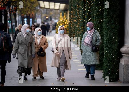 Avant la réouverture des entreprises et avant le passage à un niveau 2 pour Londres lors de la deuxième vague de la pandémie du coronavirus, les acheteurs passent devant les vitrines de Noël à l'extérieur de Selfridges, sur Oxford Street, le 30 novembre 2020, à Londres, en Angleterre. Les détaillants seront de nouveau ouverts pour Noël le 3 décembre. Banque D'Images