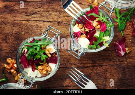 Salade de betteraves ou de betteraves à l'arugula fraîche, fromage doux et noix, bol à salade tendance, morceau sur une fourchette, fond de table de cuisine gris, espace de copie, dessus Banque D'Images