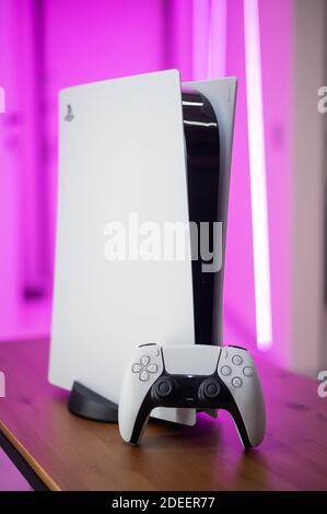 La nouvelle console de jeu Sony PlayStation 5 et la manette DualSense dans une lumière rose au néon. Moscou - novembre 28 2020. Banque D'Images