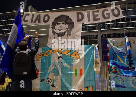 Un fan met un foulard de Naples en mémoire de Diego Armando Maradona devant les portes du stade San Paolo , dans les jours qui suivent la mort Banque D'Images