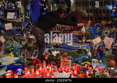 Un fan met un foulard de Naples en mémoire de Diego Armando Maradona devant les portes du stade San Paolo , dans les jours qui suivent la mort Banque D'Images