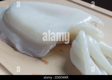Détail de la texture d'un seiche sur une planche à découper en bois. Fruits de mer, poissons et mollusques de la mer. Banque D'Images