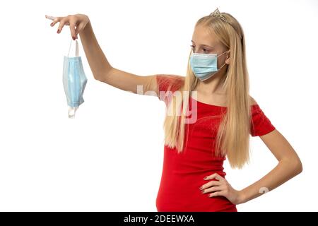 fille dans une robe rouge tenant un masque de coronavirus. isolé sur blanc. de haute qualité Banque D'Images