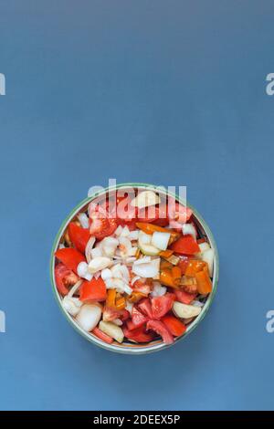 Un plateau rond rempli de fruits et légumes crus pour la cuisson sur un fond de tissu et de l'espace pour entrer le texte.Ingrédients pour faire un gazpacho. Banque D'Images