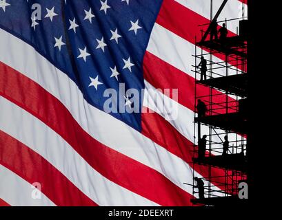 Ouvriers de construction sur échafaudage avec drapeau Stars and Stripes comme toile de fond. Image du concept: USA, économie américaine, ouvrier du col bleu... Banque D'Images