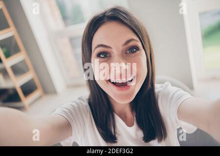 Portrait d'une charmante jeune fille adolescente qui fait un selfie plein de sourires asseyez-vous dans la maison à l'intérieur Banque D'Images