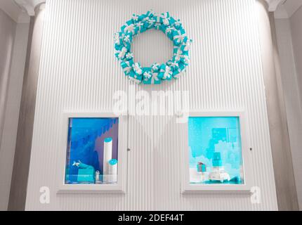 Belle décoration intérieure pour la saison de Noël. Atmosphère très sobre, blanche et bleue. Couronne de Noël très originale faite de cadeaux. Banque D'Images