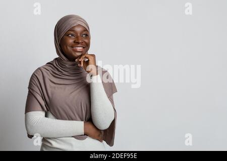 La femme noire intéressée dans hijab regardant l'espace de copie et Appuyez sur Chin Banque D'Images