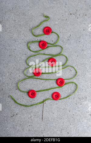 Thème de couture création de la mise à plat: Arbre de Noël en aiguille, fil et boutons sur la surface grise Banque D'Images