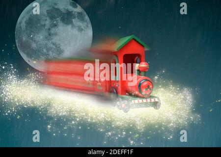 Train jouet voyageant dans la neige étincelante pour apporter des cadeaux de noël Banque D'Images