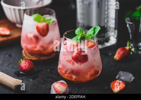 Verres de cocktail avec fraisier frais et congelé, gin et tonique Banque D'Images