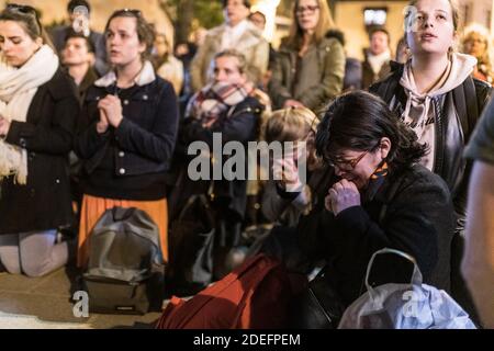 Les fidèles prient alors que les pompiers combattent pour éteindre un feu géant qui engloutit la cathédrale notre-Dame de Paris, en France, le 15 avril 2019. Le président français Emmanuel Macron s'est engagé à reconstruire le bâtiment du XIIIe siècle qui accueille chaque année des dizaines de millions de fidèles et de touristes. Photo de Daniel Derajinski/ABACAPRESS.COM Banque D'Images