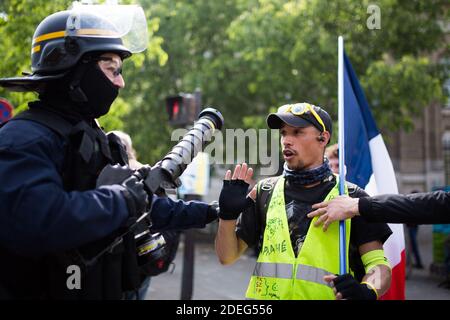 Le CRS de la police tient une arme à gaz lacrymogène pour discuter avec un gilet jaune de manifestant un drapeau français face à face lors du rassemblement annuel du jour de mai à Paris le 1er mai 2019. La police anti-émeute de Paris a tiré des gaz lacrymogène alors qu'ils se sont mis au point contre des manifestants de la ligne dure parmi des dizaines de milliers de manifestants du jour de mai, qui ont inondé la ville le 1er mai pour mettre à l'épreuve la politique de tolérance zéro de la France sur les violences de rue. Photo de Raphaël Lafargue/ABACAPRESS.COM Banque D'Images