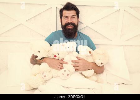 Jouets pour adultes. Détendez-vous dans la chambre. De retour dans l'enfance. Joyeux anniversaire. Homme avec barbe heureux visage tenir des jouets cadeaux. Boutique de jouets. Baccalauréat. Habitudes Puériles. Ours en peluche. Achats en ligne. Banque D'Images